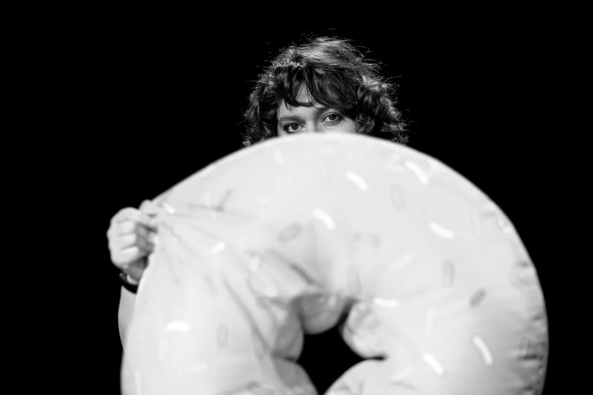 Patti Baslers süsse Seite. Patti Basler hinter einem aufblasbaren Donut.